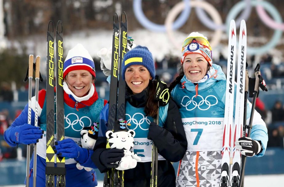 Gold medal winner Charlotte Kalla of Sweden is flanked by silver medal winner Marit Bjoergen of Norway (left) and bronze medal winner Krista Parmakoski of Finland pose after the women's 7.5km /7.5km skiathlon cross-country skiing competition at the 2018