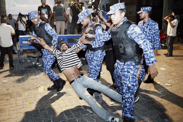 Maldivian police officers detain an opposition protestor demanding the release of political prisoners during a protest in Male, Maldives.