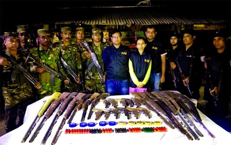 RAB members and Bangladesh Army in a joint drive arrested four terrorists (not seen in the picture) along with 25 arms and huge rounds of bullet from Bonpur Rajapara hill area of Lama upazila on Thursday night.