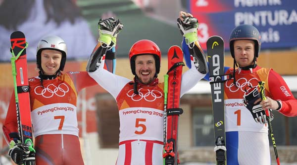 From left : Norway's Henrik Kristoffersen (silver), Austria's Marcel Hirscher (gold) and France's Alexis Pinturault (bronze) celebrate during the flower ceremony for the men's giant slalom at the 2018 Winter Olympics in Pyeongchang, South Korea on Sun