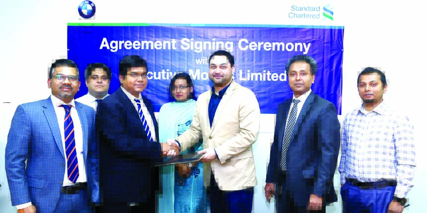 Makam E Mahmud Billah, Head of Retail Products and Segments of Standard Chartered Bank Bangladesh and Dewan Muhammad Sajid Afzal, Director (Operations) of Executive Motors Limited (authorized sole importer of BMW vehicles in Bangladesh), exchanging an ag