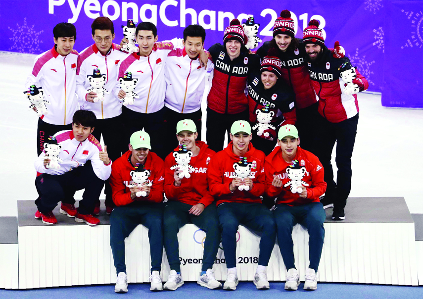 Gold medalists, Hungary men's 5000 meters short track speedskating relay team (foreground) pose for a photo with silver medalists China (back left) and bronze medalists Canada (background right) on the podium in the Gangneung Ice Arena at the 2018 Winter