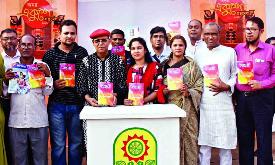 Poet Abdul Hai Shikder along with others holds the copies of a book titled 'Aroni' written by Latiful Khabira at its cover unwrapping ceremony in the city's Suhrawardy Udyan on Saturday.