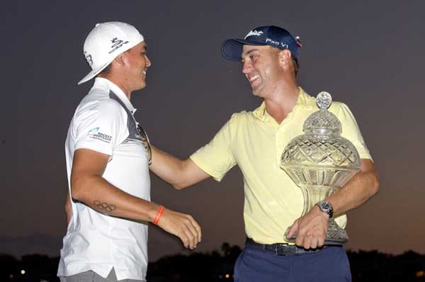 Justin Thomas (right) is congratulated by last year's winner Rickie Fowler (left) as he holds up his trophy after winning the Honda Classic golf tournament in a sudden-death playoff on Sunday in Palm Beach Gardens, Fla.
