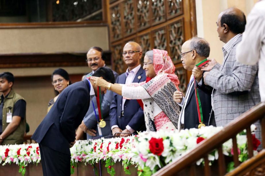 Prime Minister Sheikh Hasina placing gold medal to Rafid Adnan Khan, student of the East West University in a ceremony on Sunday.
