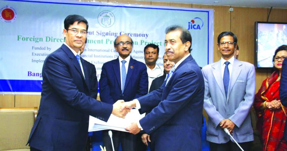 M. Akhter Hossain, DMD of Shahjalal Islami Bank Limited and Rezaul Islam, GM of Bangladesh Bank (BB), exchanging an agreement signing documents for JICA-funded Foreign Direct Investment Promotion Project (FDIPP) at BB head office in the city recently. Tak