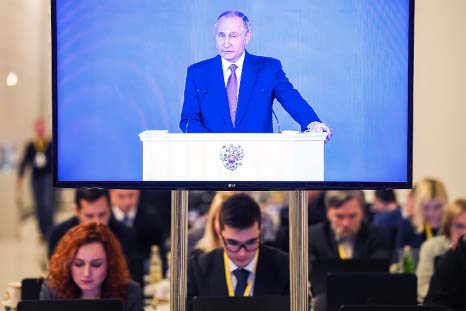 Journalists watch a live broadcast of Russian President Vladimir Putin's address to the Federal Assembly in a pressroom at Moscow's Manezh exhibition centre on Thursday.