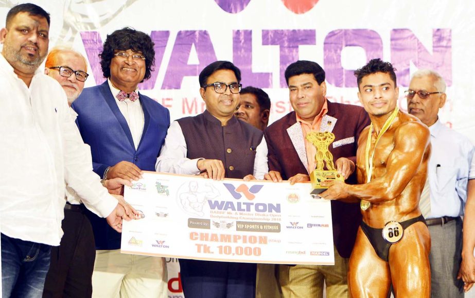Mayor of Dhaka South City Corporation Sayeed Khokon distributes the trophy to a winner of the Walton BABF Mr Dhaka & Master Dhaka Open Bodybuilding Competitions as the chief guest at the Auditorium in the National Sports Council Tower on Sunday.