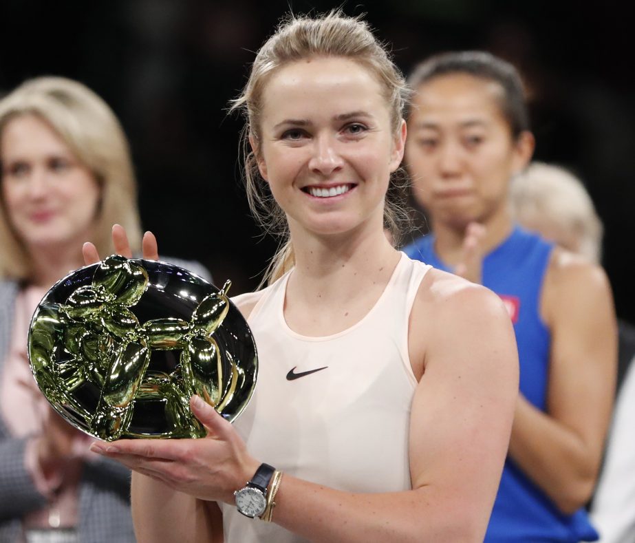 Elina Svitolina of Ukraine holds the trophy after defeating Zhang Shuai of China (right rear) during the final round of the Tie Break Tens tournament at Madison Square Garden on Monday in New York. The Tie Break Tens' New York event is a one-day day exhi