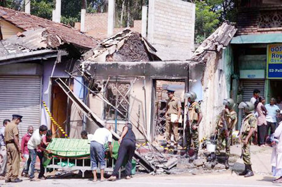 Sri Lanka's Special Task Force stand guard near a burnt house after a clash between two communities in Digana, central district of Kandy, on Tuesday.