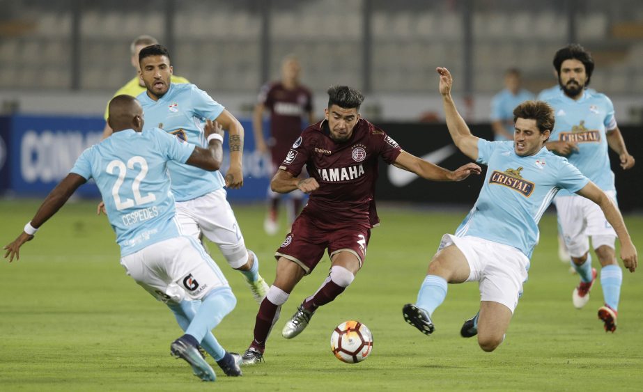 Marcelino Moreno of Argentina's Lanus (center) fights for the ball, surrounded of players of Peru's Sporting Cristal during a Copa Sudamericana soccer match in Lima, Peru on Wednesday.