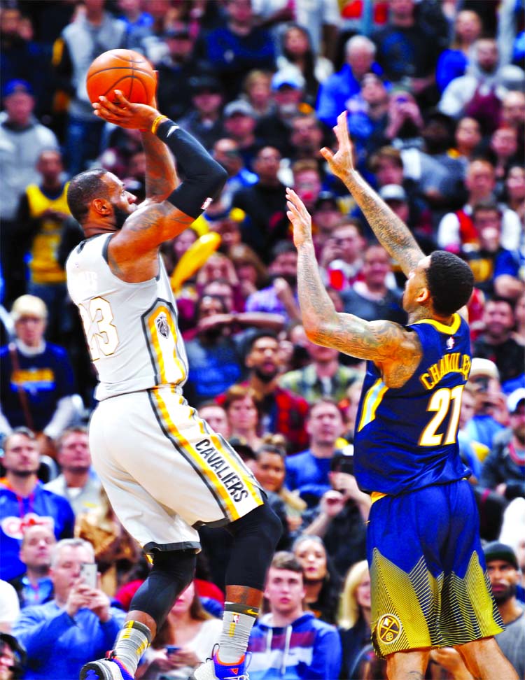 Cleveland Cavaliers forward LeBron James (left) shoots and scores over Denver Nuggets forward Wilson Chandler late in the second half of an NBA basketball game in Denver on Wednesday. The Cavaliers won 113-108.