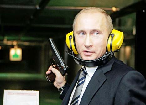 Russian President Vladimir Putin stands with a gun at a shooting gallery of the GRU military intelligence headquarters