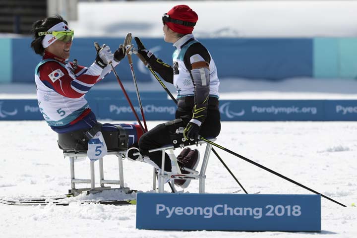 Lee Doyeon of South Korea (left) celebrates with Chu Beibei of China after completing their race in the Biathlon Sitting Women's 6km at the Alpensia Biathlon Centre during the 2018 Winter Paralympics in Pyeongchang, South Korea on Saturday.