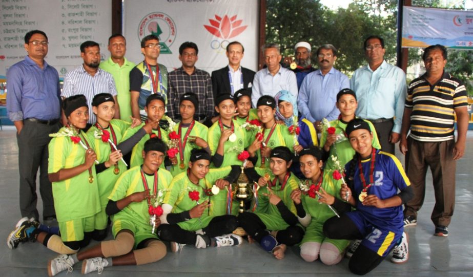 Members of Rajshahi Division with the trophy and guests pose for photo at Shaheed Captain M Mansur Ali Handball Stadium on Tuesday.