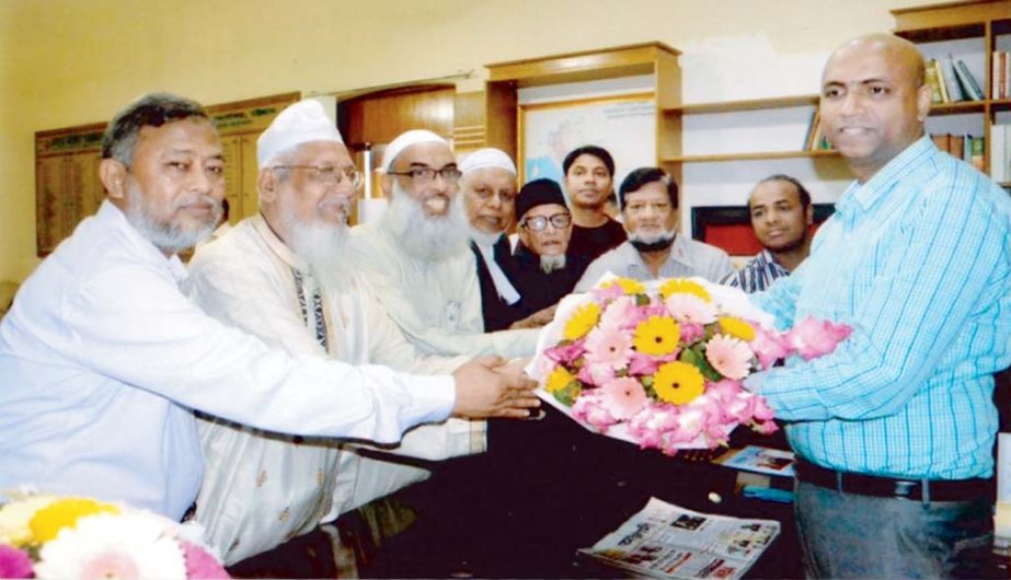 The leaders of the Chittagong central Eid Jamaat committee led by Principal Dr Abdul Karim handing over bouquet to newly assigned Deputy Commissioner of Chittagong Md Elias Hossain at his latter's office.