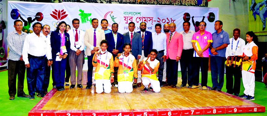 The winners of the Weightlifting Competition of the Girls' Division of the Bangladesh Youth Games with the guests and officials of Bangladesh Weightlifting Federation pose for photograph at the Gymnasium in the National Sports Council on Thursday.