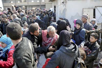 Photo shows Syrian civilians with their belongings as they flee from fighting between the Syrian government forces and rebels, near Hamouria in eastern Ghouta, a suburb of Damascus, Syria on Friday.