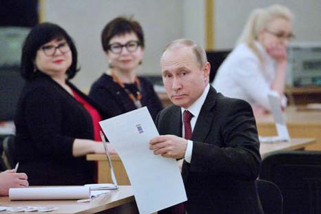 Russian President Vladimir Putin prepares to vote at a polling station in Moscow on Sunday.