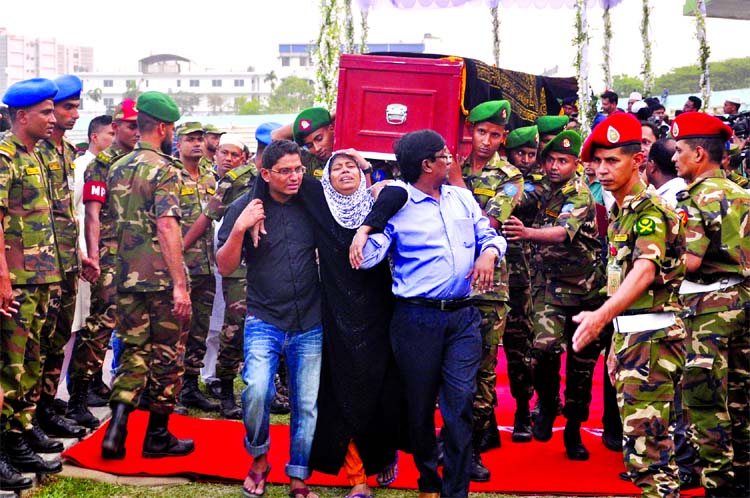 Bodies of plane crash victims being taken to coffin carrier from the Army Stadium by their relatives after Namaz-e-Janaza on Monday.