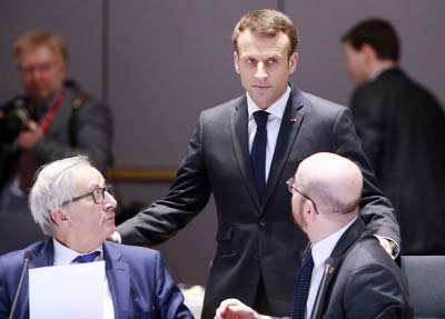 European Commission President Jean-Claude Juncker, left, speaks with French President Emmanuel Macron, center, and Belgian Prime Minister Charles Michel during a breakfast meeting at an EU summit in Brussels on Friday