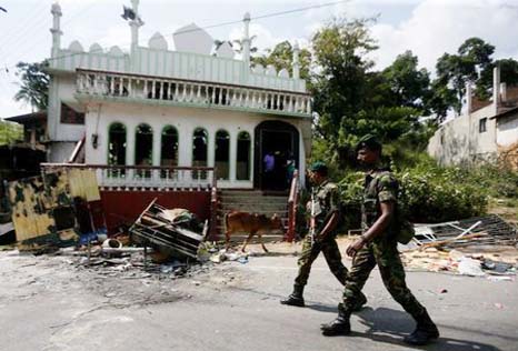 Sri Lanka's Special Task Force soldiers walk past a damaged mosque after a clash between two communities in Digana, central district of Kandy, Sri Lanka.