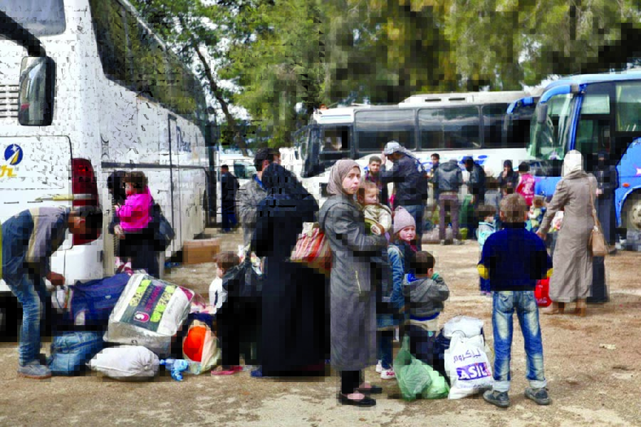 Syrian civilians and rebel fighters arrive in the town of Qalaat al-Madiq, north of Hama, on Sunday after leaving the Eastern Ghouta enclave under an evacuation deal.