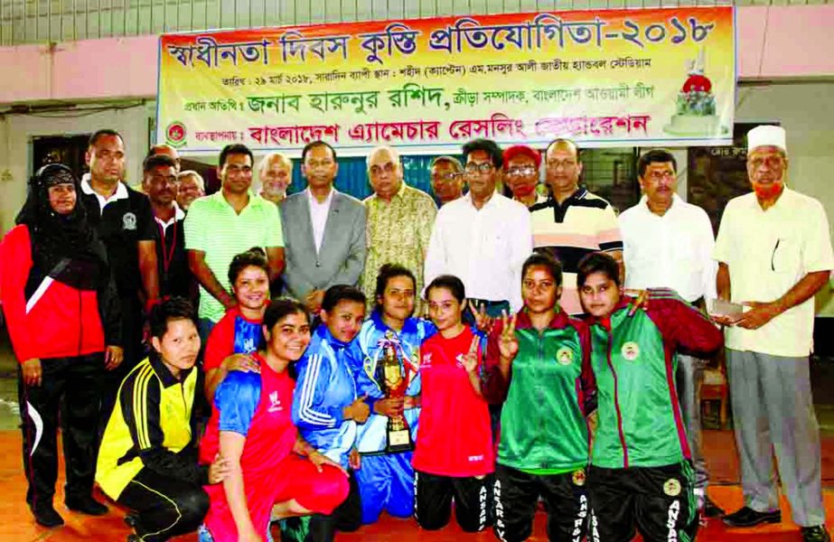 Members of Bangladesh Ansar, the champions of the Women's Division of the Independence Day Wrestling Competition with the chief guest Secretary of Youth and Sports of Bangladesh Awami League Harunur Rashid and the officials of Bangladesh Amateur Wrestlin