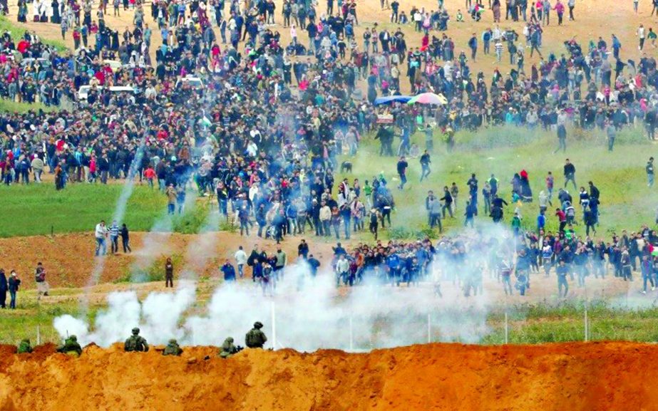 Palestinians run from tear gas fired by Israeli troops during clashes in Gaza.