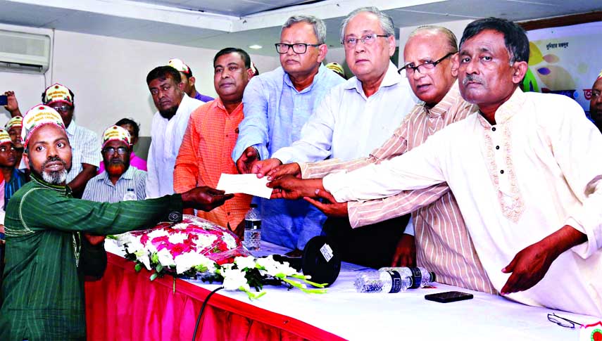 Forest and Environment Minister Anisul Islam Mahmud distributing cheque of financial help among the poor construction workers at a ceremony organised by Imarat Nirman Sramik Union, Bangladesh in the seminar hall of IDEB in the city on Saturday.