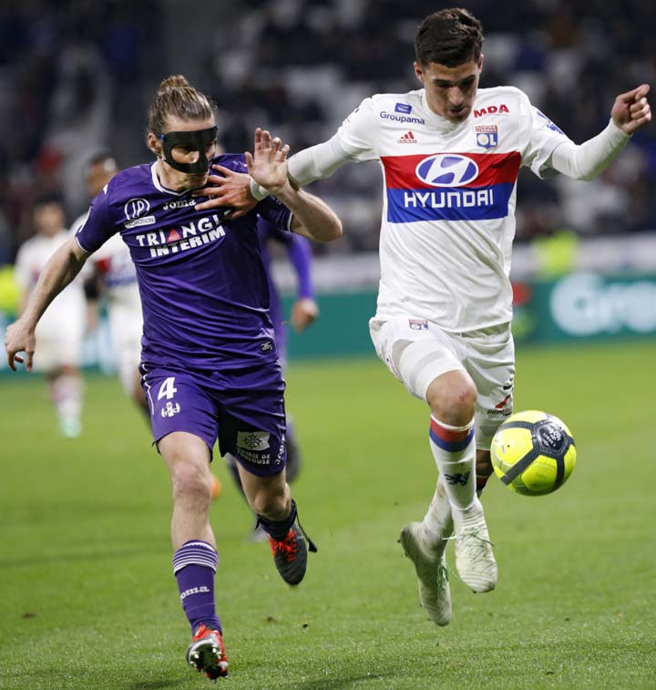 Toulouse's Yannick Cahuzac (left) challenges with Lyon's Houssem Aouar, during their French League One soccer match in Decines, near Lyon, central France on Sunday.