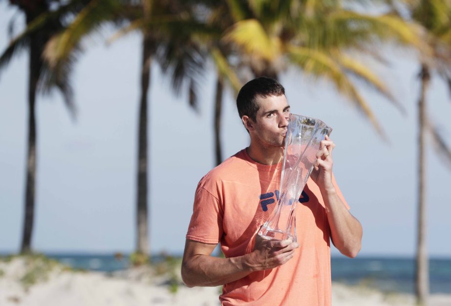 John Isner of the United States poses with his trophy on Crandon Park Beach after defeating Alexander Zverev of Russia in the men's final at the Miami Open tennis tournament Sunday in Key Biscayne, Fla. Isner won 6-7 (4), 6-4, 6-4.