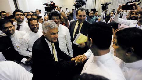 Sri Lankan Prime Minister Ranil Wickremesinghe shakes hands with his party members who supported him after he survived a no confidence vote in the parliament in Colombo, Sri Lanka.