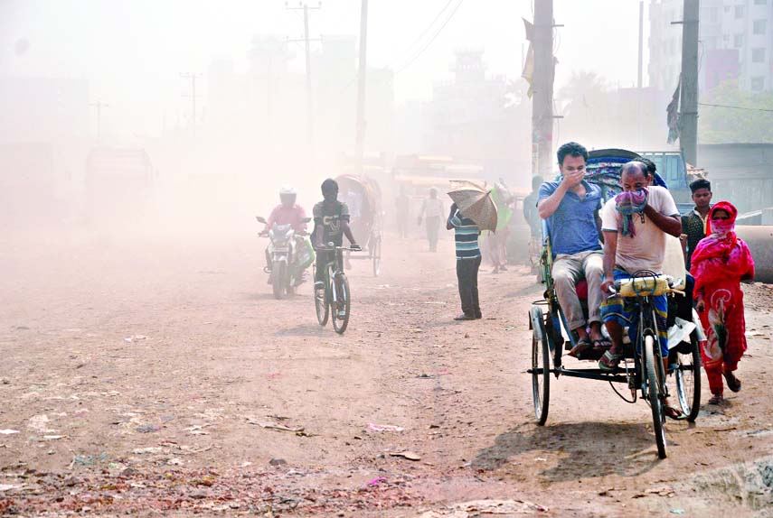 Pedestrians and also passengers covering their noses to protect themselves from dusty pollution going to their destinations. The situation remains the same for long due to digging of the road for utility services. The snap was taken from the city's Kazla