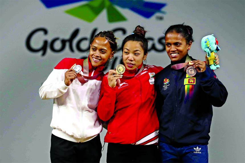 India's women's 48kg Weightlifting gold medalist Saikhom Mirabai Chanu (center) stands with silver medalist of Mauritius Marie Hanitra Ranaivosoa (left) and bronze medalist of Sri Lanka Dinusha Gomes at the Commonwealth Games in Gold Coast, Australia on