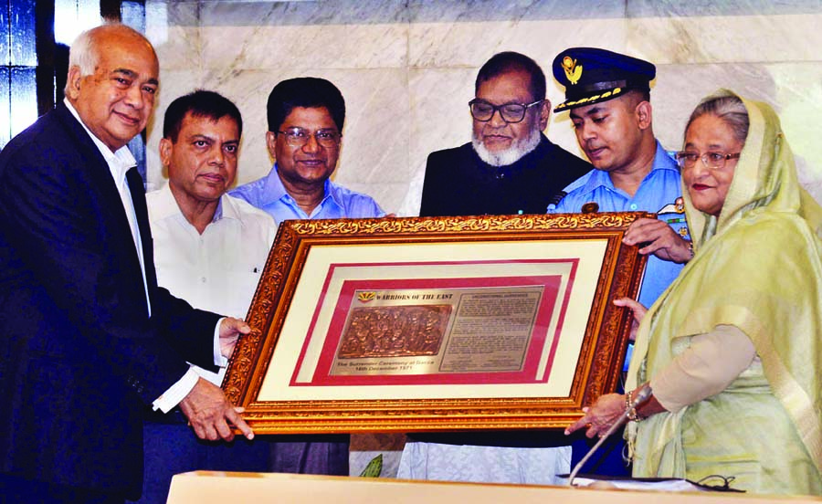 Prime Minister Sheikh Hasina handing over honorary crest to Housing and Public Works Minister, Sub-Sector Commander of 1 No Sector and Head of a delegation of Eastern Command Freedom Fighters and Civil Officials of India Engineer Mosharaf Hossain at her o