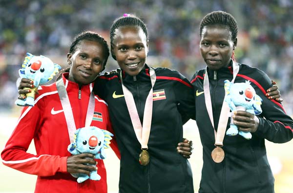 Women's 10,000m gold medalist Uganda's Stella Chesang (centre) stands with silver medalist Kenya's Stacy Ndiwa (left) and bronze medalist Uganda's Mercyline Chelangat on the podium at Carrara Stadium during the 2018 Commonwealth Games at the Gold Coas