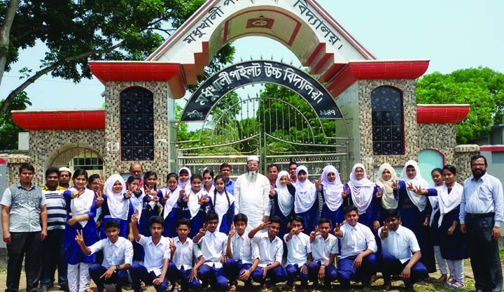 MADHUKHALI (Faridpur): Meritorious students of Madhukhali Pilot High School who achieved JSC scholarship showing V-sign with their teachers after publishing the result on Monday.