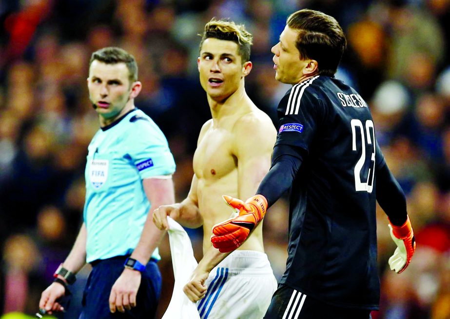 Juventus goalkeeper Wojciech Szczesny (right) reacts after failing to save Real Madrid's Cristiano Ronaldo's, center, penalty shot during a Champions League quarter-final, 2nd leg soccer match between Real Madrid and Juventus at the Santiago Bernabeu st