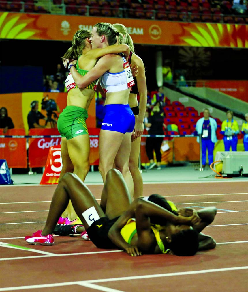 Scotland's Eilidh Doyle (standing right) celebrates winning the silver medal as gold medal winner Jamaica's Janieve Russell lies on the track at Carrara Stadium during the Commonwealth Games on the Gold Coast, Australia on Thursday.