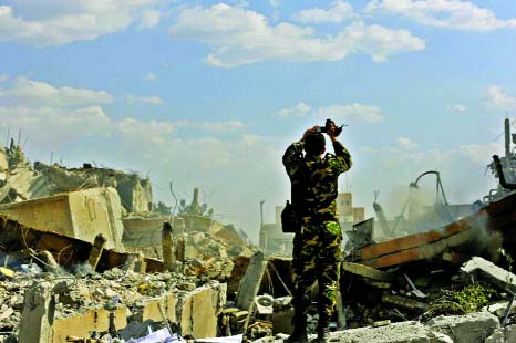 A Syrian soldier inspects the wreckage of a building described as part of the Scientific Studies and Research Centre (SSRC) compound in the Barzeh district north of Damascus, during a press tour organised by the Syrian government after US-led strikes.