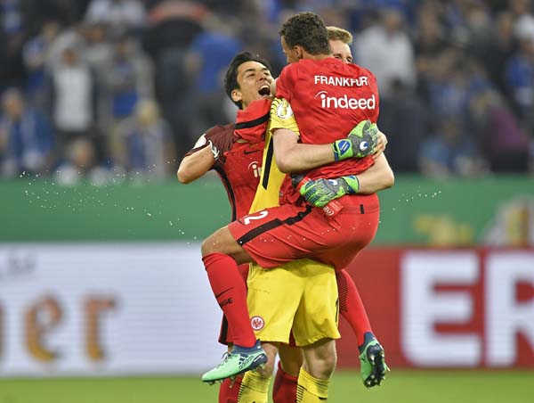 Frankfurt's players celebrate goalkeeper Lukas Hradecky after winning the German soccer cup semifinal match between FC Schalke 04 and Eintracht Frankfurt in Gelsenkirchen, Germany on Wednesday. Schalke was defeated by Frankfurt with 0-1.