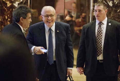 Former New York Mayor Rudy Giuliani,( center) , smiles as he leaves Trump Tower, on Friday in New York.
