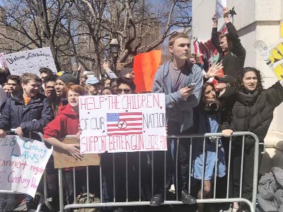 Students walk out of their classrooms to demand action on gun reform in Washngton Square park, New York City on Friday.