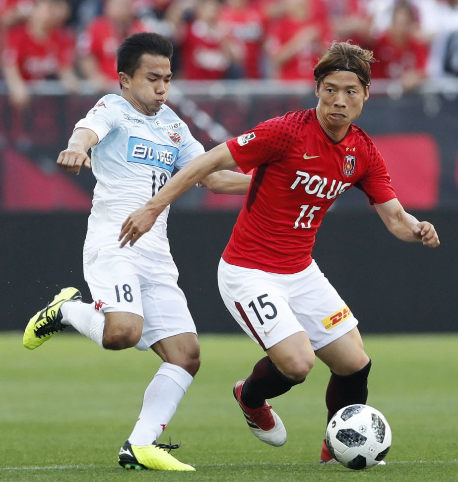 Chanathip Songkrasin (left) of Consadole Sapporo and Kazuki Nagasawa (right) of Urawa Reds fight for the ball during their J1 League match at Saitama Stadium in Saitama, north of Tokyo on Saturday.