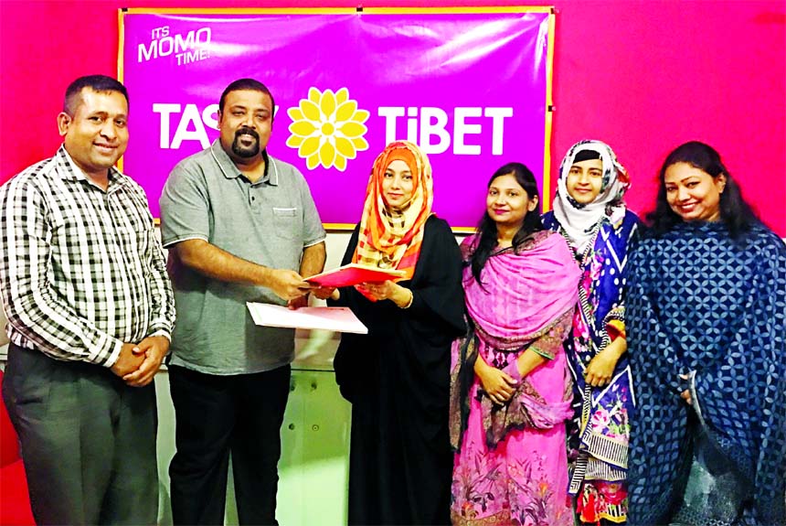 Sabbir Rahman Tanim, Managing Director of Tasty Tibet Limited and Hafyzun Nessa, Managing Partner of Taeam (a readymade food supplier company), exchanging an agreement signing documents at its office in the city on Tuesday. High officials from both the or