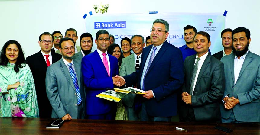 Md. Arfan Ali, Managing Director of Bank Asia and Buddhika Samarasinghe, Director of Business Engagement at Nathan Associate London Limited, exchanging the documents after signing on grant allocation for financial inclusion with capacity building of small