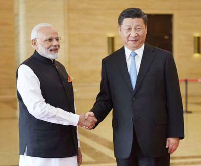 Chinese President Xi Jinping shakes hands with Indian Prime Minister Narendra Modi (L) during their meeting in Wuhan, China on Friday.