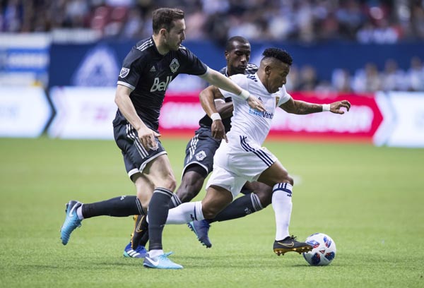 Real Salt Lake's Joao Plata (front right) controls the ball past Vancouver Whitecaps' Jordon Mutch, left, and Ali Ghazal (back) during the first half of an MLS soccer match on Friday in Vancouver, British Columbia.