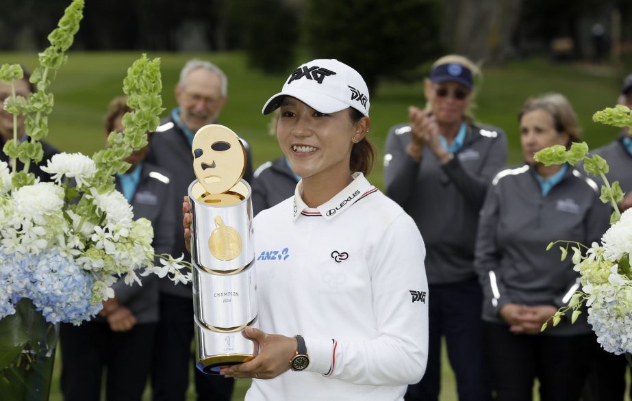 Lydia Ko of New Zealand, poses with her trophy on 18th green of the Lake Merced Golf Club after winning the LPGA Mediheal Championship golf tournament in Daly City, Calif on Sunday. Ko won the tournament on the first playoff hole against Minjee Lee.